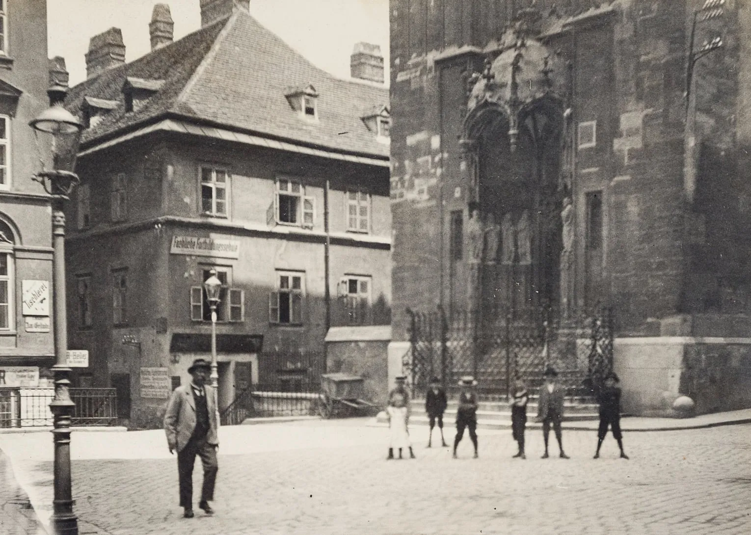 Fotografie des Passauer Platzes um 1900 mit Kindern vor dem Portal von Maria am Gestade